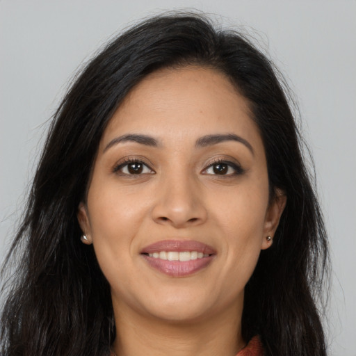 Joyful latino young-adult female with long  brown hair and brown eyes