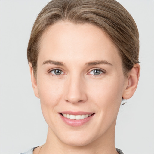 Joyful white young-adult female with medium  brown hair and grey eyes