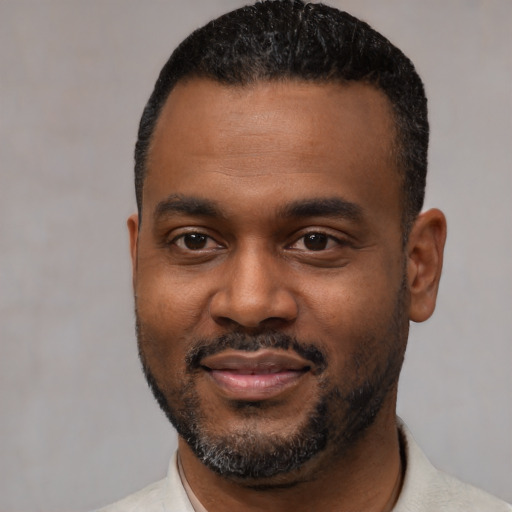 Joyful black young-adult male with short  black hair and brown eyes