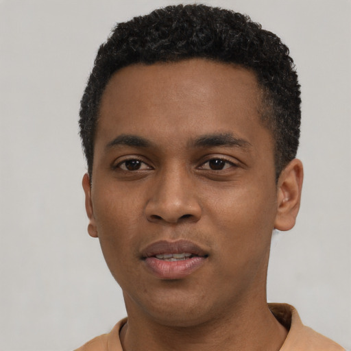 Joyful black young-adult male with short  black hair and brown eyes