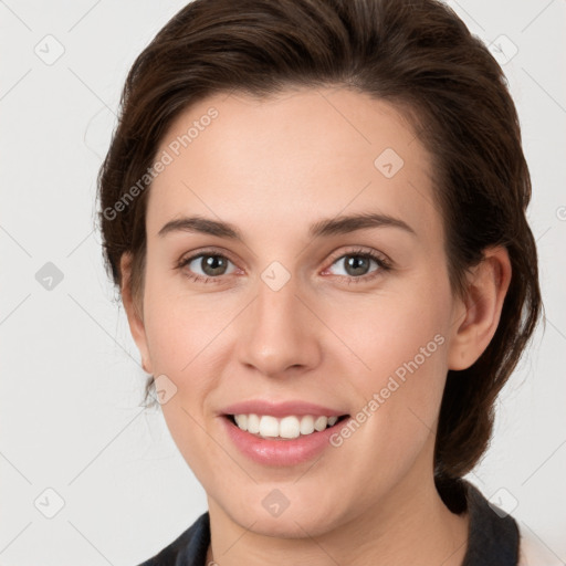 Joyful white young-adult female with medium  brown hair and grey eyes