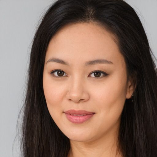 Joyful asian young-adult female with long  brown hair and brown eyes