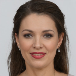 Joyful white young-adult female with long  brown hair and grey eyes