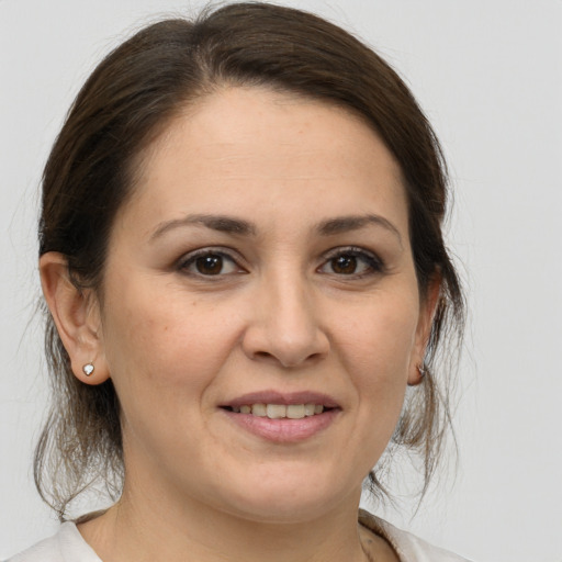 Joyful white adult female with medium  brown hair and brown eyes