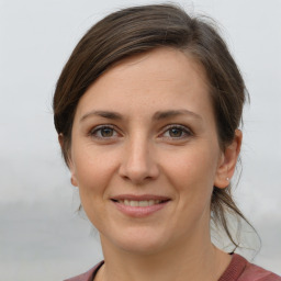 Joyful white young-adult female with medium  brown hair and grey eyes