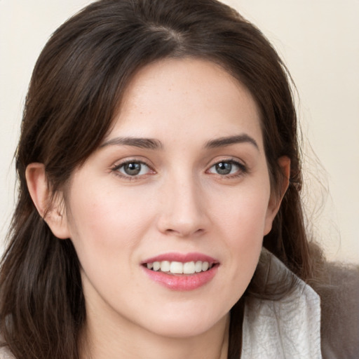 Joyful white young-adult female with long  brown hair and brown eyes