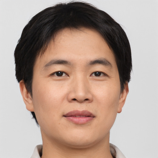 Joyful asian young-adult male with short  black hair and brown eyes