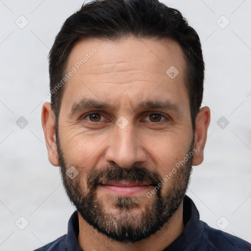 Joyful white adult male with short  black hair and brown eyes