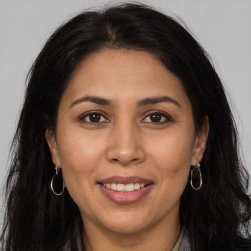 Joyful latino young-adult female with long  brown hair and brown eyes