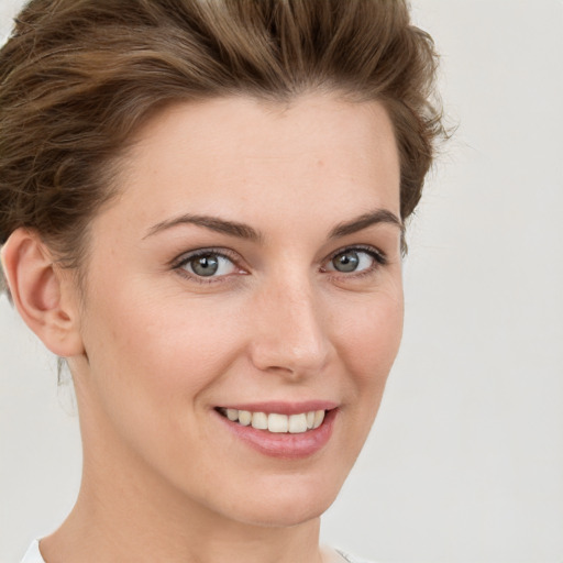 Joyful white young-adult female with short  brown hair and green eyes