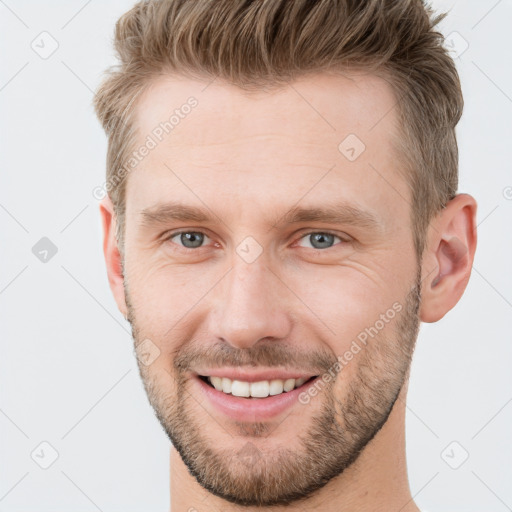 Joyful white young-adult male with short  brown hair and grey eyes