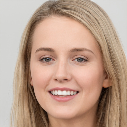 Joyful white young-adult female with long  brown hair and grey eyes