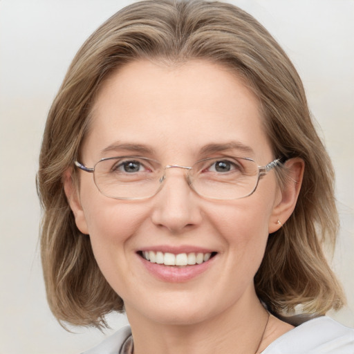 Joyful white adult female with medium  brown hair and blue eyes