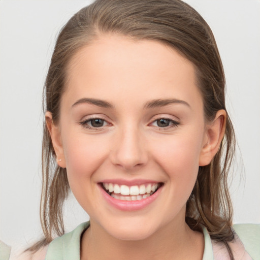 Joyful white young-adult female with medium  brown hair and grey eyes