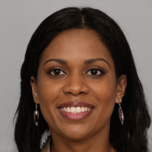 Joyful black young-adult female with long  brown hair and brown eyes