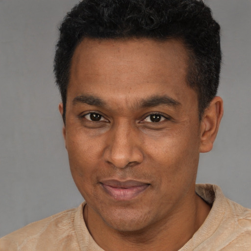 Joyful latino adult male with short  black hair and brown eyes
