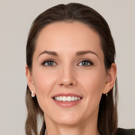 Joyful white young-adult female with long  brown hair and grey eyes