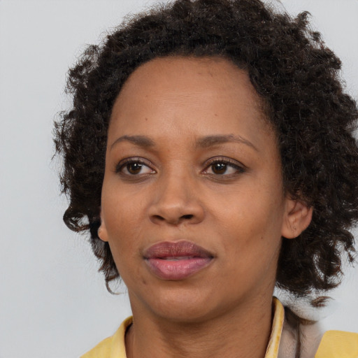 Joyful black adult female with medium  brown hair and brown eyes