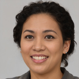 Joyful latino adult female with medium  brown hair and brown eyes