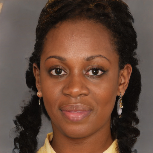 Joyful black young-adult female with long  brown hair and brown eyes