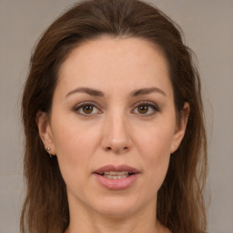 Joyful white adult female with long  brown hair and brown eyes