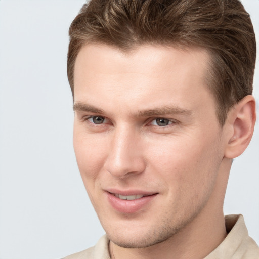 Joyful white young-adult male with short  brown hair and grey eyes