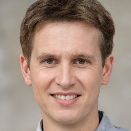 Joyful white adult male with short  brown hair and grey eyes