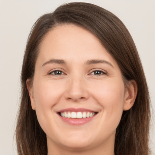 Joyful white young-adult female with long  brown hair and brown eyes