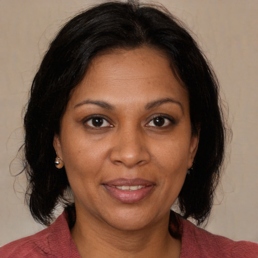 Joyful black adult female with medium  brown hair and brown eyes