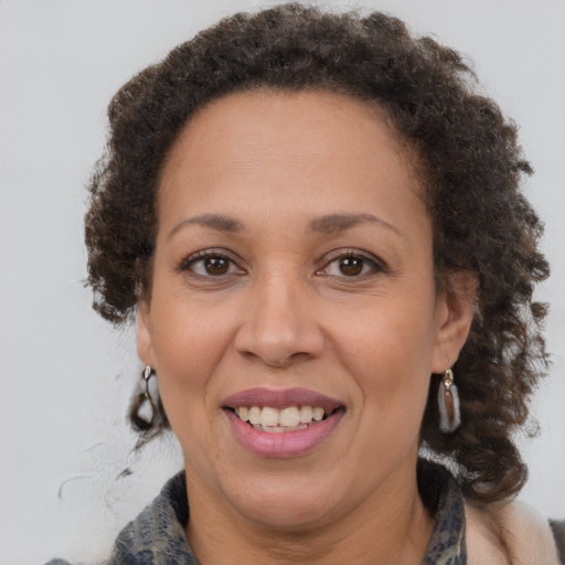 Joyful black adult female with medium  brown hair and brown eyes