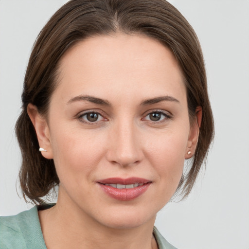 Joyful white young-adult female with medium  brown hair and grey eyes