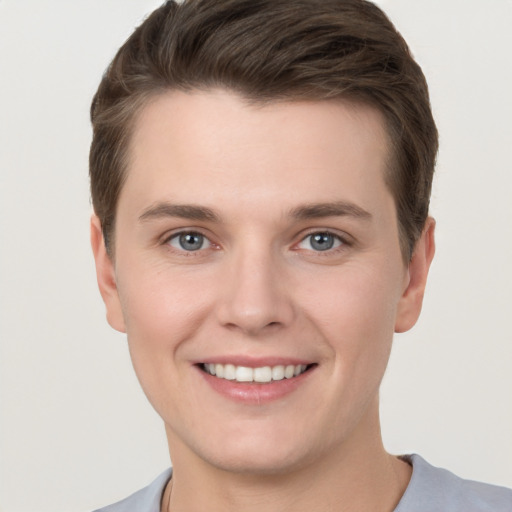 Joyful white young-adult male with short  brown hair and grey eyes