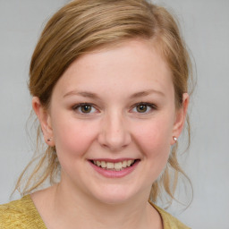 Joyful white young-adult female with medium  brown hair and blue eyes