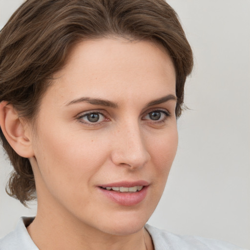 Joyful white young-adult female with medium  brown hair and grey eyes