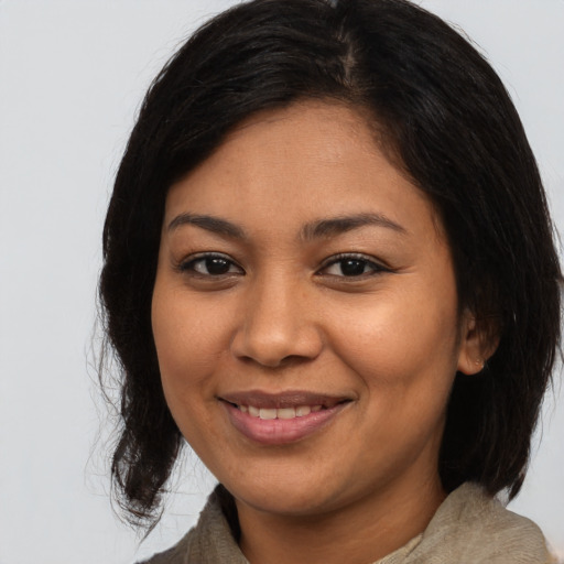 Joyful latino young-adult female with medium  brown hair and brown eyes