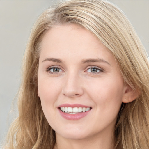 Joyful white young-adult female with long  brown hair and blue eyes