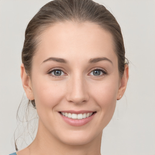 Joyful white young-adult female with medium  brown hair and grey eyes