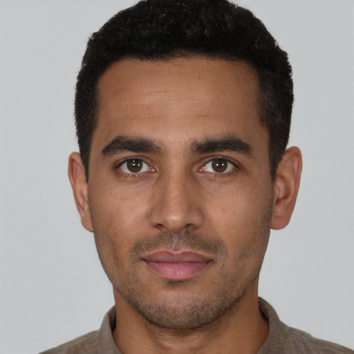 Joyful latino young-adult male with short  black hair and brown eyes