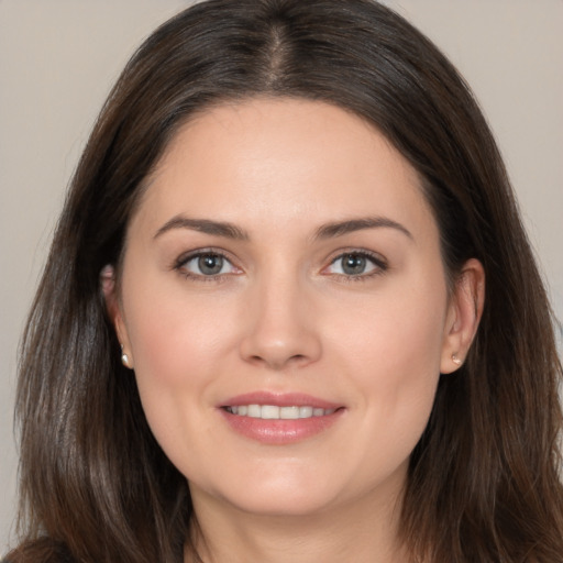 Joyful white young-adult female with long  brown hair and brown eyes