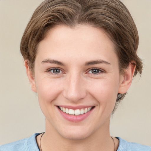 Joyful white young-adult female with short  brown hair and grey eyes