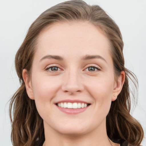 Joyful white young-adult female with medium  brown hair and blue eyes