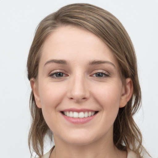 Joyful white young-adult female with medium  brown hair and grey eyes