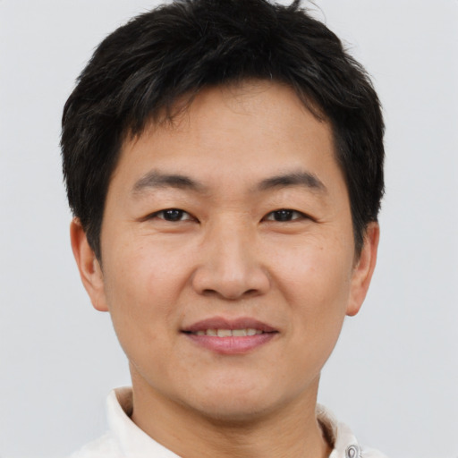 Joyful asian young-adult male with short  brown hair and brown eyes