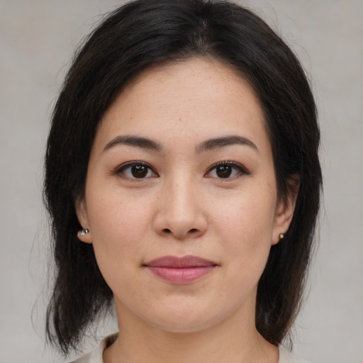 Joyful asian young-adult female with medium  brown hair and brown eyes