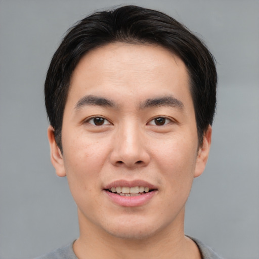 Joyful asian young-adult male with short  brown hair and brown eyes