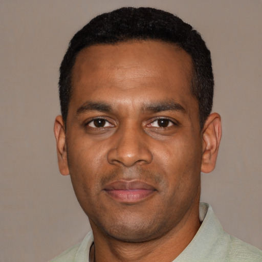 Joyful black young-adult male with short  black hair and brown eyes