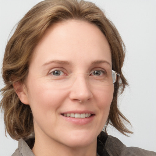 Joyful white adult female with medium  brown hair and blue eyes