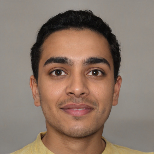 Joyful latino young-adult male with short  brown hair and brown eyes