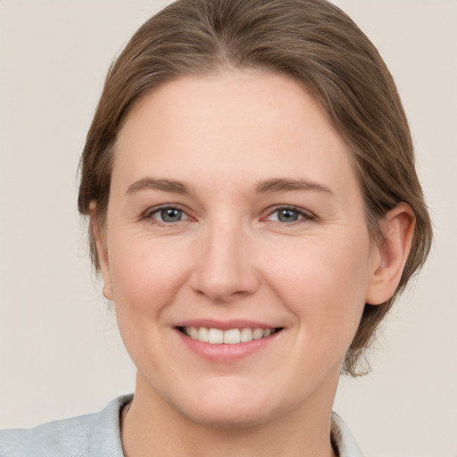 Joyful white young-adult female with medium  brown hair and grey eyes