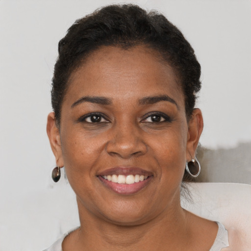 Joyful black young-adult female with short  brown hair and brown eyes
